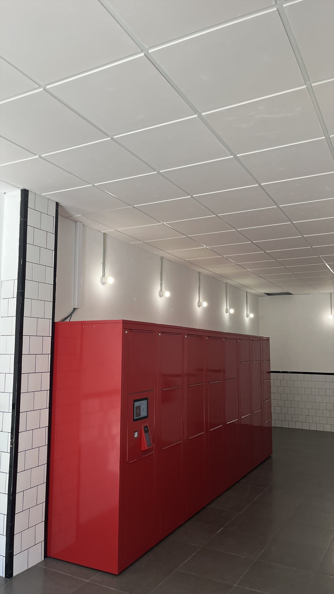 Módulo de taquillas rojas con pantalla táctil en el interior del local